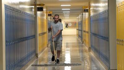 A man is cleaning the campus floor